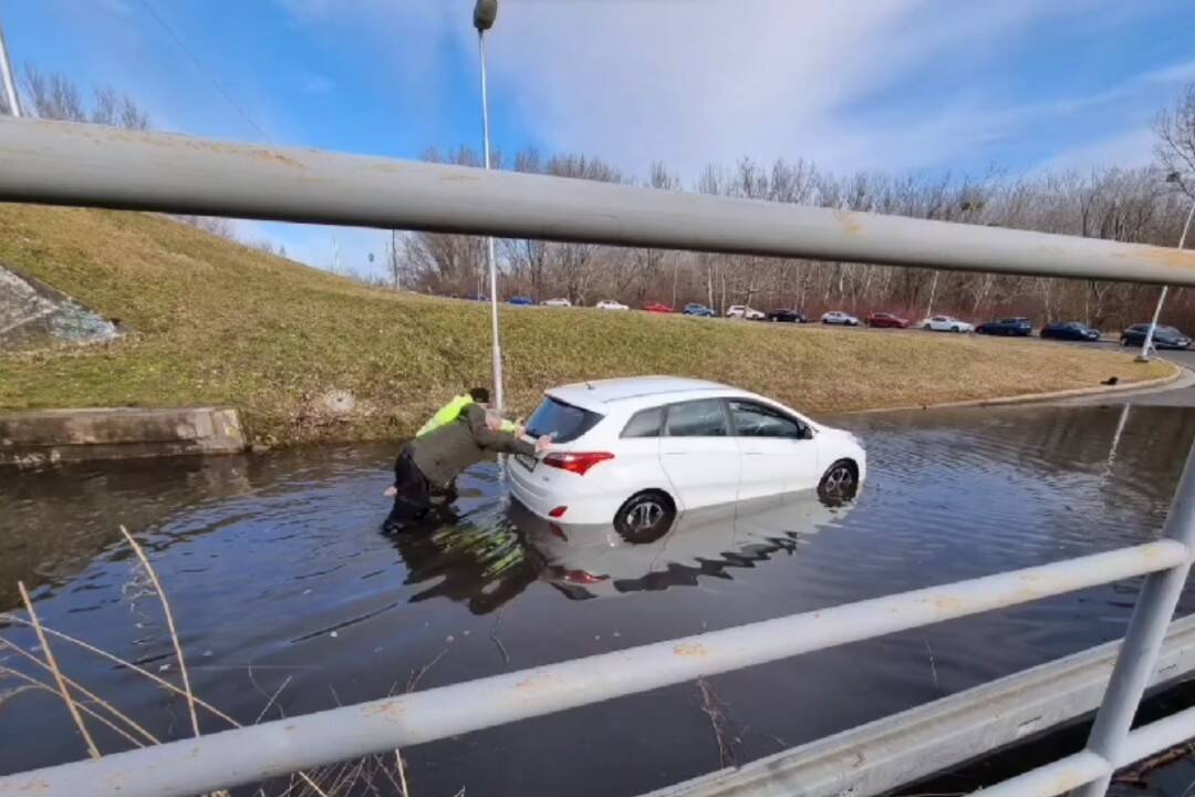 Foto: VIDEO: Nohy si namočil, aj keď nie je leto. Policajt v Petržalke pomohol vytlačiť zaplavené auto